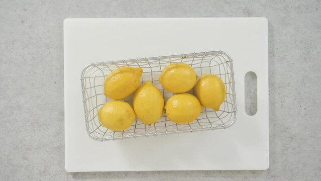 Flat lay. Whole lemons in a wired basket to bake a lemon pound cake.