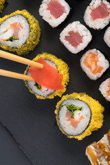 set of japanese rolls on a black tray top view