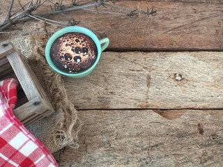 cup of coffee and napkin on wood background 