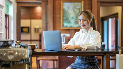 Fototapeta na wymiar Happy businesswoman working from home on a laptop computer.