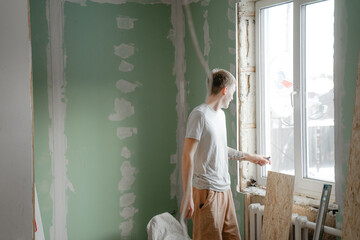 room renovation, interior renovation, the guy aligns the walls in the house