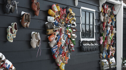 Colorful clogs against the background of a wooden wall. - 554673419