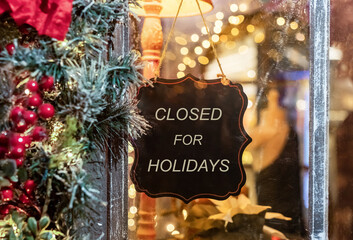 Closed for Christmas holidays, New Year vacations. text on signboard, board on window of cafe, shop, store in winter