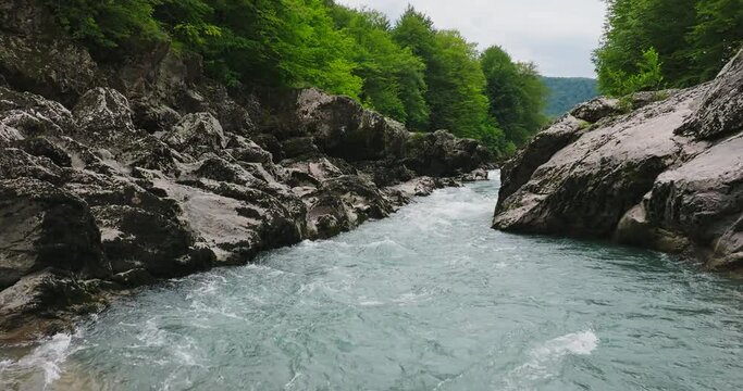 Aerial view of Mountain river and road. Flying over a mountain gorge. Slow motion 120 fps.
