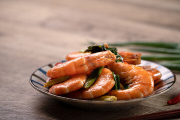 Delicious pan-fried shrimp on dark wooden table background.