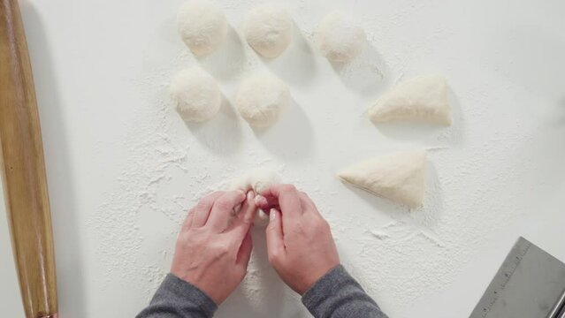 Flat lay. Rolling bread dough with a french rolling pin to make homemade flatbread.