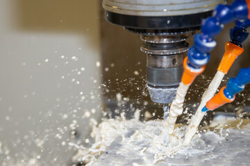 The CNC milling machine cutting the  mold parts with liquid coolant method..