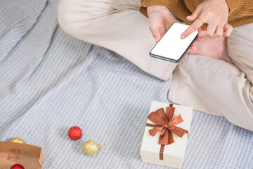 Merry Christmas and Happy Holidays! Young woman with a beautiful face in a yellow shirt shows joy with gift boxes in a house with a Christmas tree decorated with Christmas tree.  Portrait before Xmas