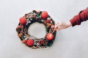 Christmas wreath with four candles. Lightning the first candle on the first Advent Sunday. Swiss...