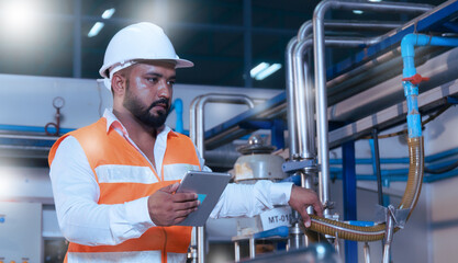 Professional asian male engineer in helmet using tablet to work, inspect and maintain electrical cabinet, machine