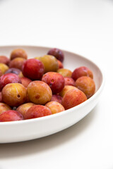 Fototapeta na wymiar plate full of small raw plums