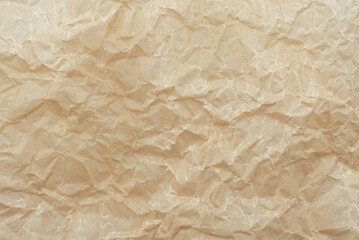 Background of crumpled parchment or craft paper in brown color