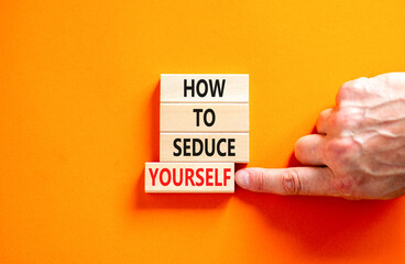 How to seduce yourself symbol. Concept word How to seduce yourself on wooden blocks. Businessman hand. Beautiful orange table orange background. Business and how to seduce yourself concept. Copy space
