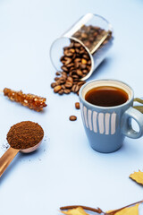 Fototapeta premium Still life with a cup of black coffee, ground coffee and roasted coffee beans in the background