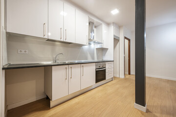 Conventional kitchen cabinets just installed in an open kitchen with a metal pillar