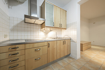 in front of a kitchen with light wood cabinets, appliances and stainless steel countertop