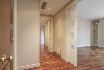 Entrance hall of an empty house with jatoba wood parquet floors, white woodwork and smooth walls