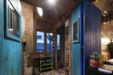 Hall of a restaurant with blue wooden doors, hydraulic ceramic floors and large light bulbs