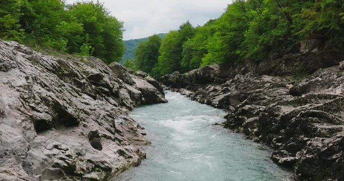 Aerial view of Mountain river and road. Flying over a mountain gorge. Slow motion 120 fps.