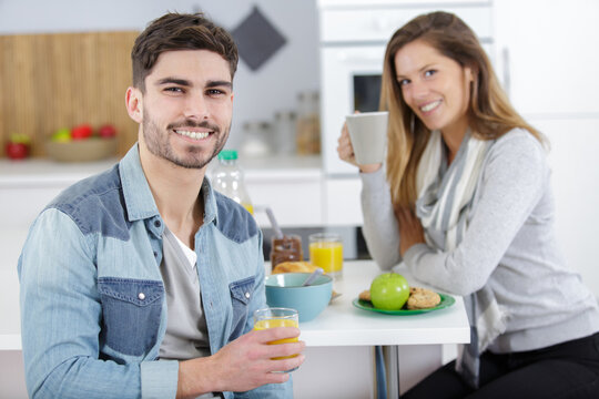 image of young woman and man preparing breakfast in kitchen