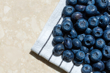 blue blueberries on a towel on a light background copy space