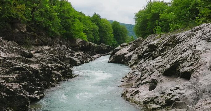 Aerial view of Mountain river and road. Flying over a mountain gorge. Slow motion 120 fps.