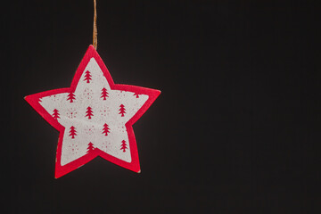 Red glitter star shaped christmas decoration isolated on black background