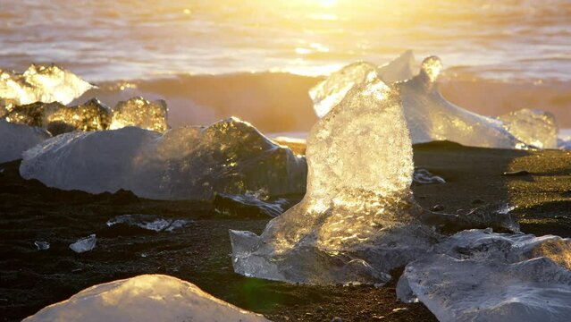 Diamond Beach in Iceland, Icebergs Shining on Black Volcanic Sand at Sunset, Clear Ice Crashed by Ocean Waves, Shot in 8K Resolution 4320p