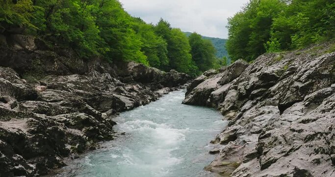 Aerial view of Mountain river and road. Flying over a mountain gorge. Slow motion 120 fps.