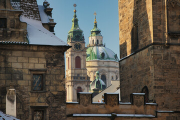 Obraz premium View from Charles Bridge with St. Nicolas Church behind Bridge Tower in winter time. Prague. Czech Republic.