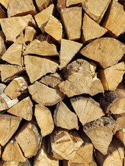 View of chopped firewood from logs piled together for storage. Close up of wooden background. Collection of dry village wood as a source of energy