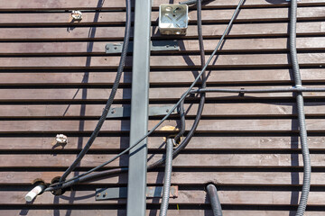 wires on the wall of a wooden building. old wooden building in the city or countryside. facade of an old house. daylight.