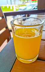 Glass of orange juice on wooden table Puerto Escondido Mexico.
