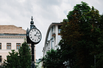 Fototapeta na wymiar Street clock on pillar in the city close-up.