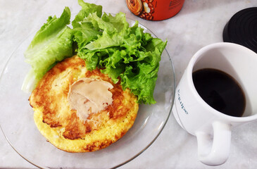Healthy snack containing omelet, peanut butter, lettuce and cup of coffee.