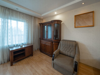 Modern interior of living room in apartment. Wooden furniture. Grey sofas. Door to balcony.