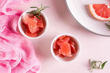 Peeled pieces of grapefruit and rosemary in a bowl on the table. Cocktail ingredients. Top view
