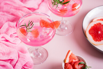Homemade pink cocktail with ice and rosemary in glasses on the table - Powered by Adobe