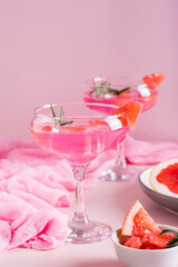 Pink cocktail with rosemary in glasses on the table. Pink food concept. Vertical view