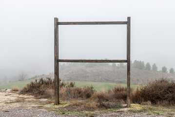 Landscape Fog-shrouded trees seen through a poster frame.
