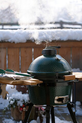 outdoor grilling on the balcony at a cold winter day with fresh snow