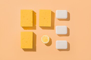 Geometric layout square pattern sponge for washing and lemon and bar of soap. Beige background.