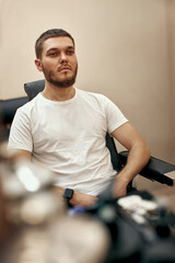 Fototapeta na wymiar male bearded client in chair in barber shop