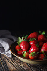 A bowl with ripe bright strawberry in rustic style