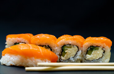 Japanese food. Sushi on a black background. Rolls with red fish, Philadelphia.