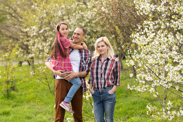 Happy family spending good time together in spring in a flowering garden