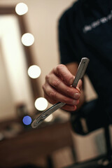 barber hand testing the sharpness of blade