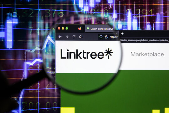 Linktree company logo on a website with blurry stock market developments in the background, seen on a computer screen through a magnifying glass