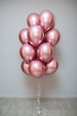 set of pink chrome balloons on wall background