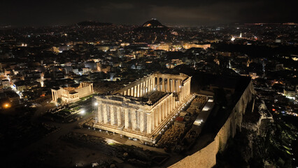 Aerial drone night shot of iconic illuminated landmark Acropolis hill and the Masterpiece of...